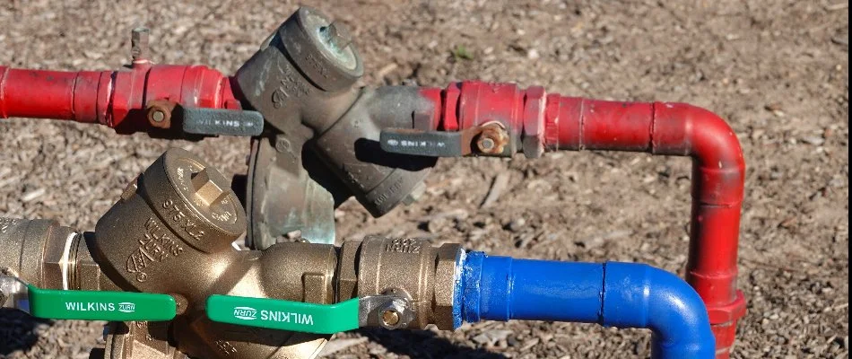 Backflow prevention devices of an irrigation system in Cary, NC, above the ground.