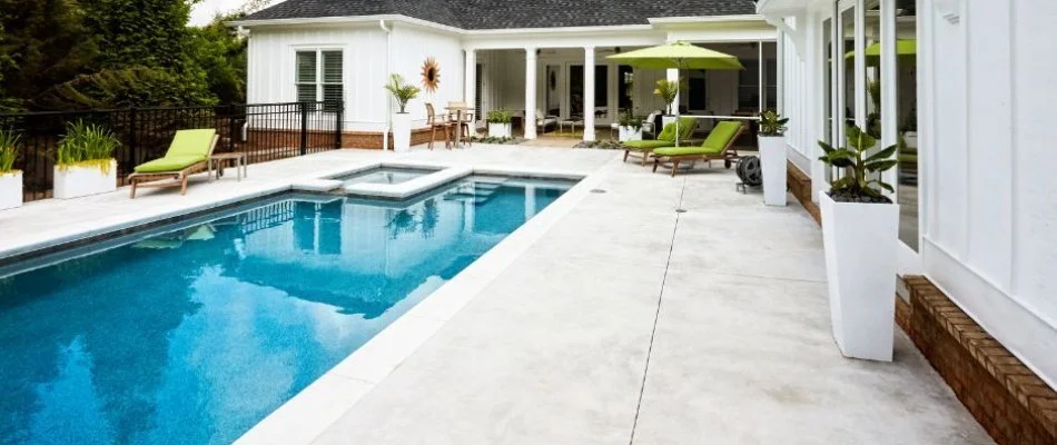 Swimming pool with green furniture on deck in Cary, NC.