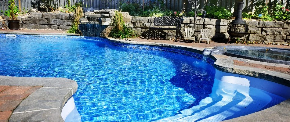 Large pool with rock water feature on a property in Cary, NC.