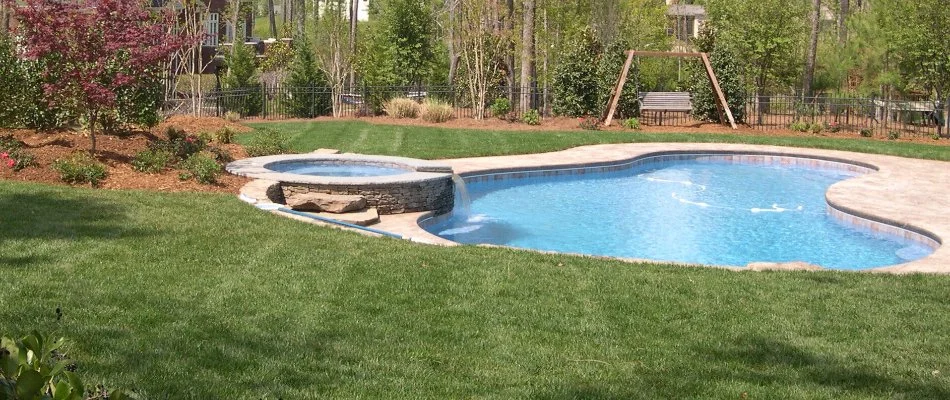 Pool in yard with green grass on property in Cary, NC.