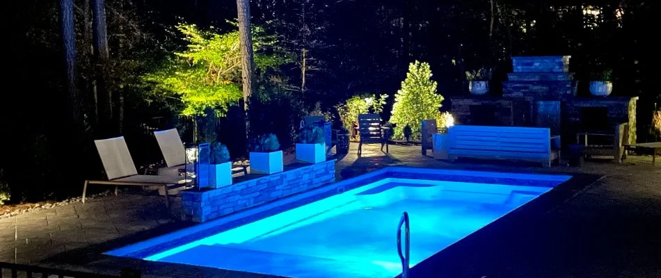 Swimming pool lit up at night on a property in Cary, NC.