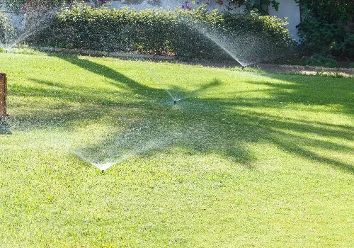 Grass being watered by multiple sprinkler heads.